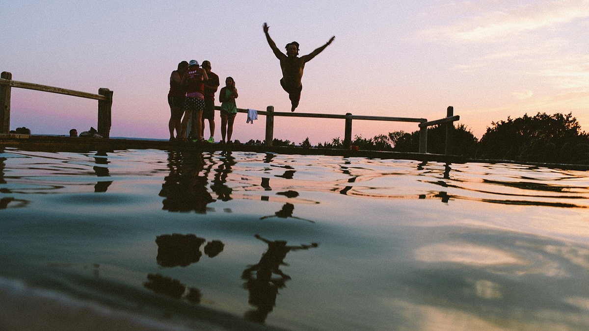 Image of swimmer jumping into water. Used for article about prearing for open water swimming in the pool.